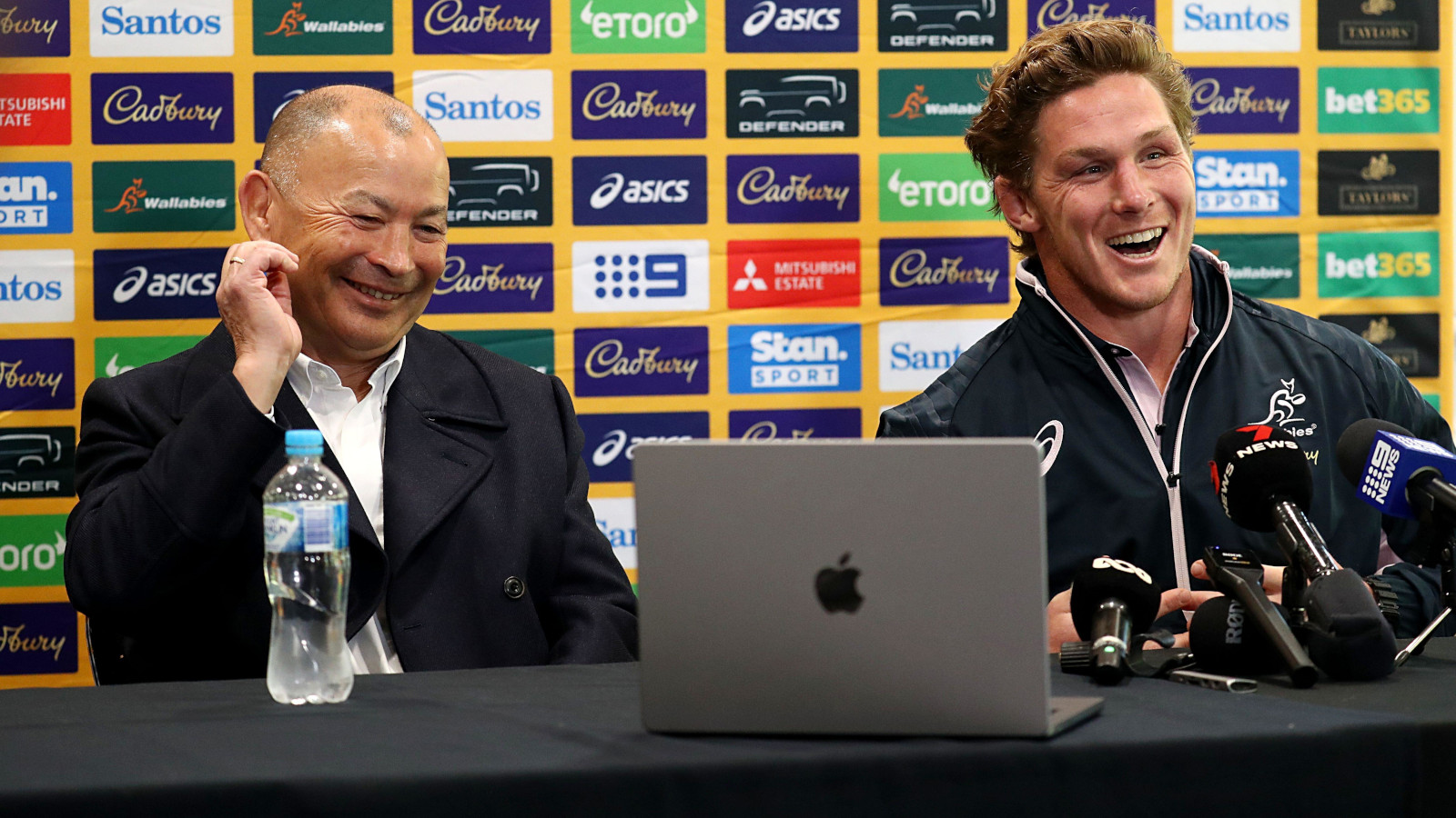 Eddie Jones and Michael Hooper laughing during a Wallabies press conference in 2023.