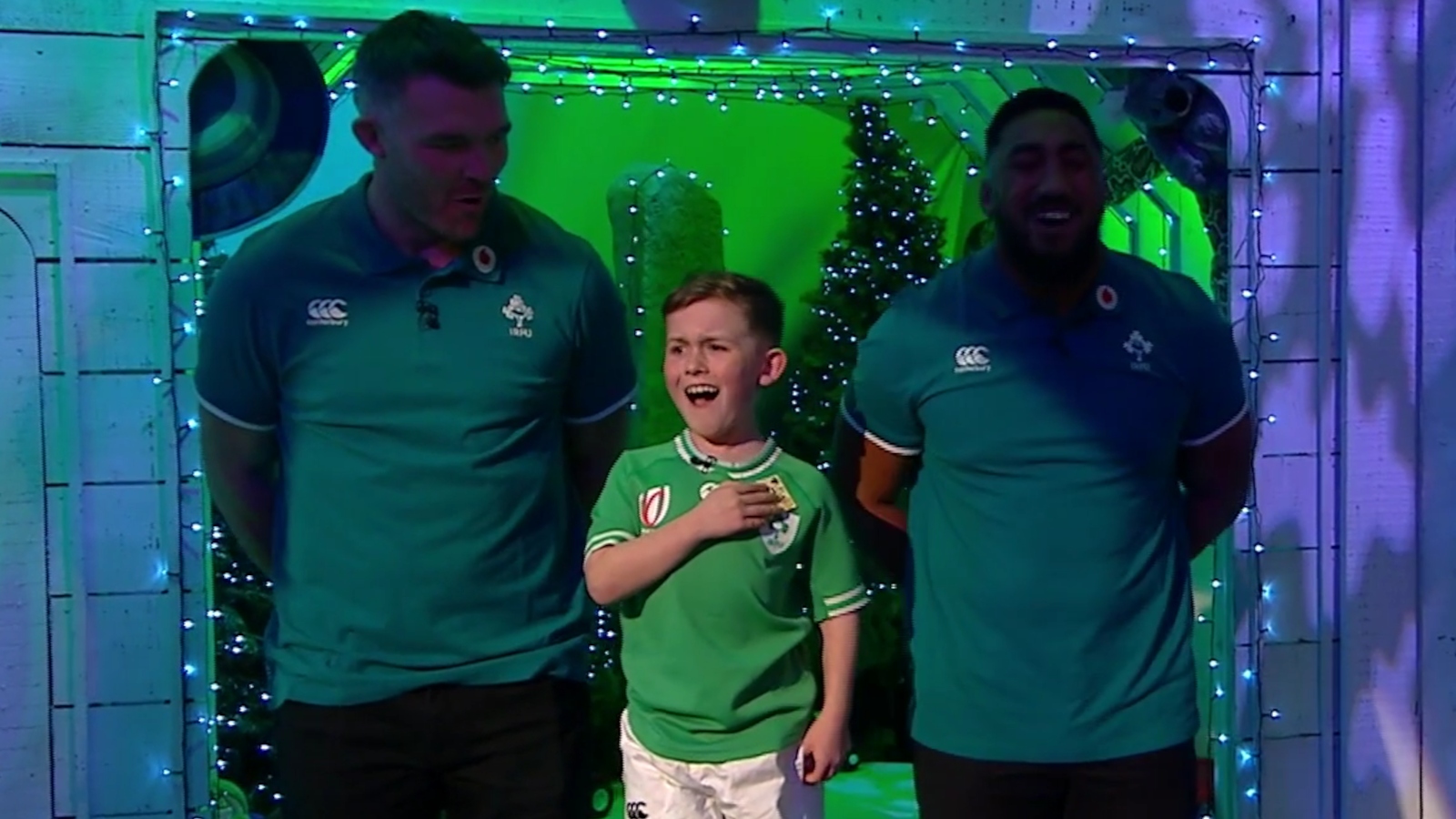 Bundee Aki and Peter O'Mahony with a young fan singing Ireland's Call.