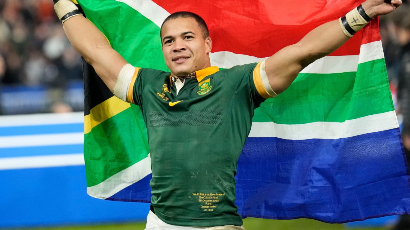 Cheslin Kolbe holding South Africa flag.
