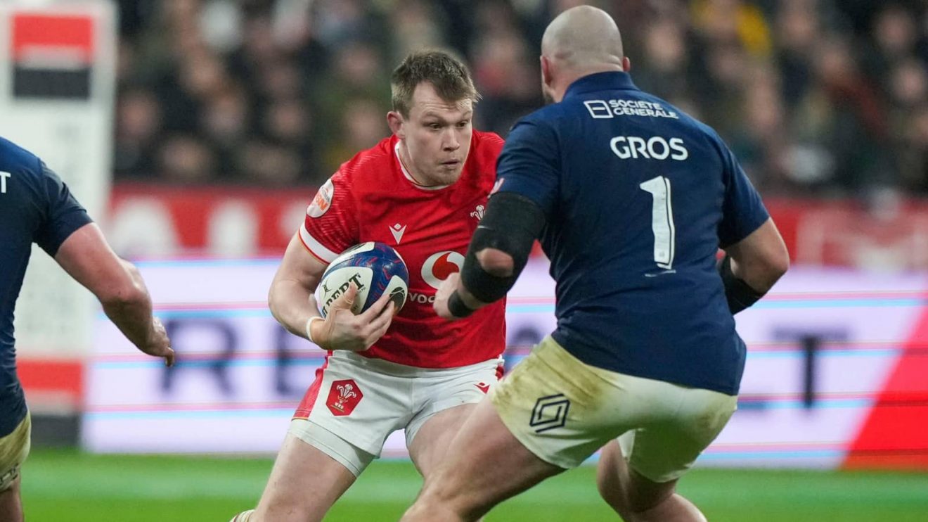 Wales' Nick Tompkins, center, runs at France's Jean-Baptiste Gros during the Six Nations rugby union match between France and Wales at the Stade de France in Saint-Denis