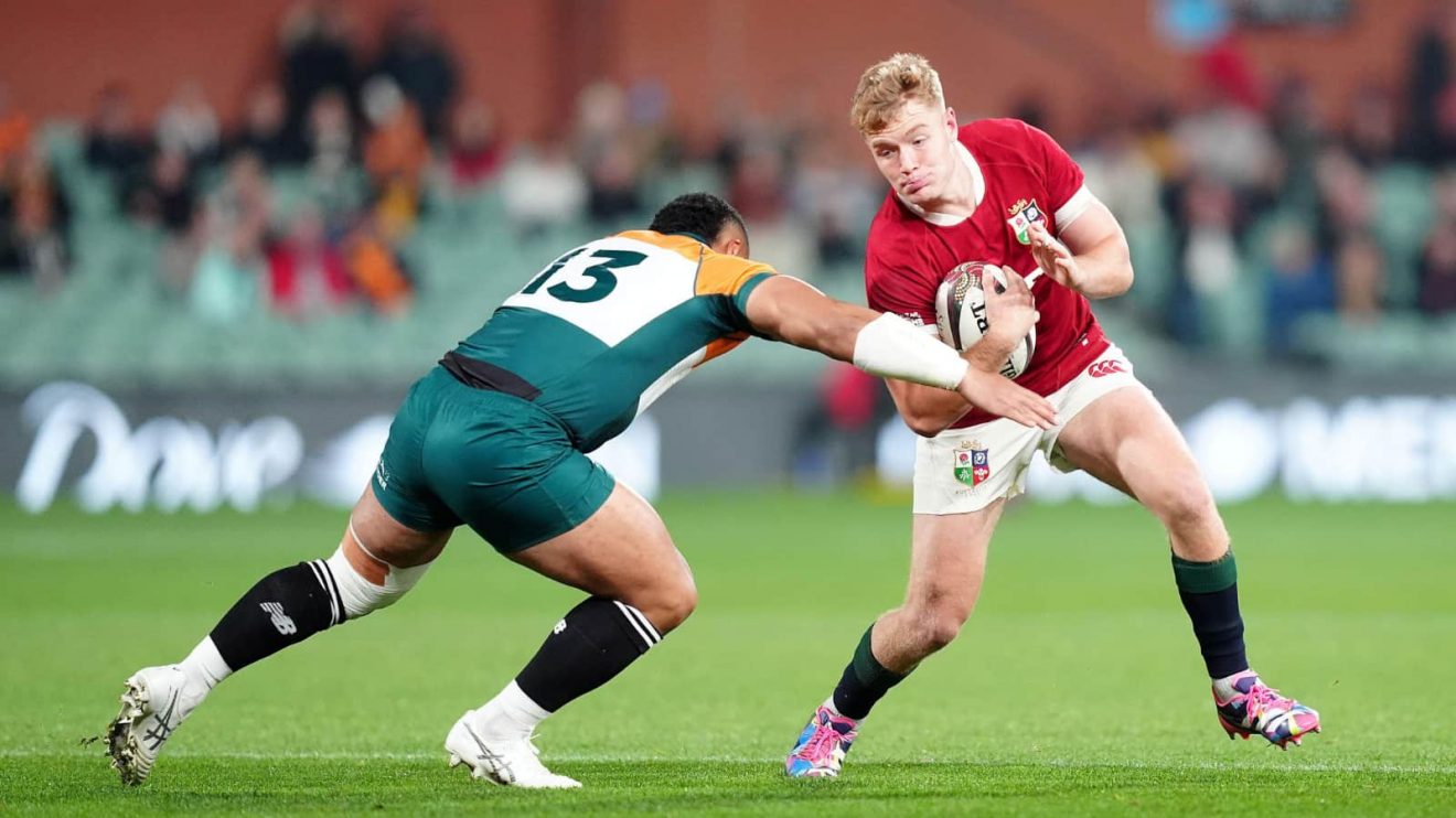 British and Irish Lions' Fin Smith (right) is tackled by AUNZ Invitational XV's Ngani Laumape during the Qatar Airways Lions Tour 2025 match at the Adelaide Oval, Australia